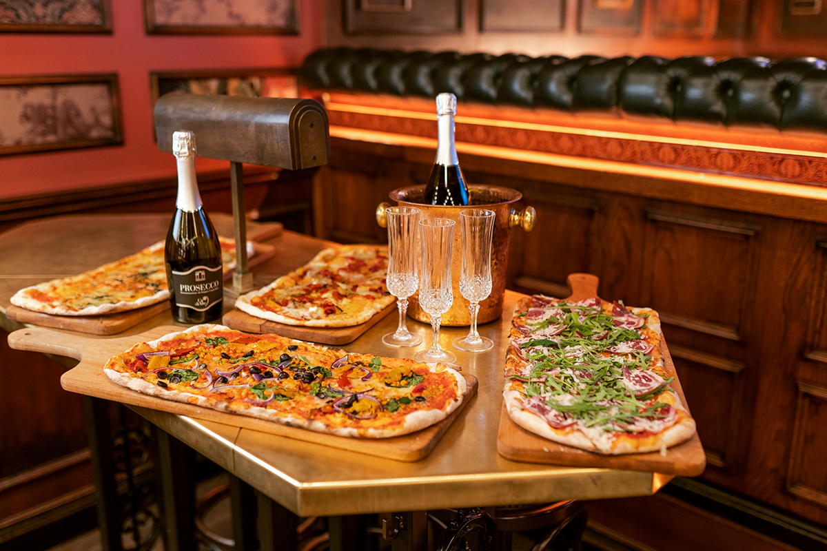 Pizza and prosecco on a table at Flight Club